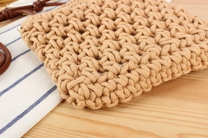 Close-up of handmade woven cotton rope bag showing detailed texture and leather handle
