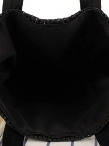 Interior view of black woven tote bag with fabric lining and internal storage pocket