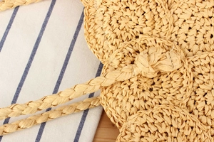 Close-up of handmade woven straw bag featuring intricate circular patterns and natural fiber texture