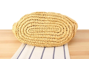 Detailed close-up of a handwoven straw bag base with a sturdy oval shape and natural texture