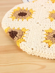 Handmade crochet cotton bag with sunflower patterns on a light wood background