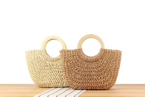 Detail handgewebter Strohhandtaschen mit runden Holzgriffen in Beige- und Brauntönen