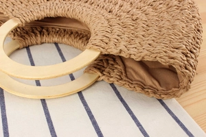 Detailaufnahme der gewebten Tasche mit Holzgriffen und glänzendem Seidenfutter