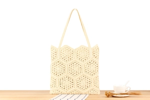 Close-up of handmade crochet tote bag featuring intricate hexagonal floral knit patterns