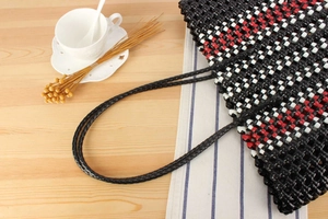 Detailed top view of a handmade woven tote bag with black, white and red checkered pattern