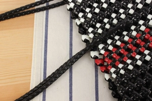 Close-up of tricolor checkered woven basket with black, white, and red pattern detail