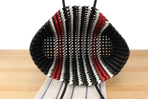 Detailed top view of handmade woven tote bag showing tricolor red black white texture