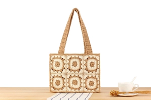 Close-up of retro crochet floral patterns on a cotton woven tote with a wide strap