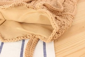 Detail of handmade woven bag featuring beige fabric lining and reinforced stitching