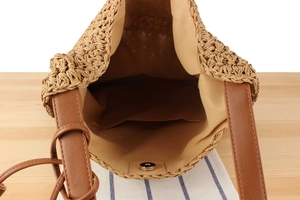Detailed interior of woven straw shoulder bag with inner pocket and magnetic closure