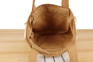 Detail view of woven tote interior showing fabric lining with zipper and slip pockets