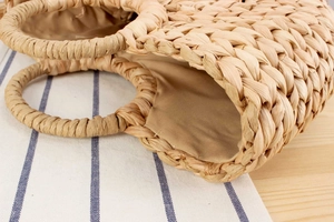 Détail macro du tressage en écorce de maïs et doublure en lin d'un sac en paille