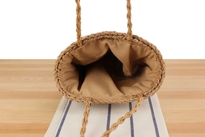 Close-up of handmade straw tote bag showing interior fabric lining and woven texture