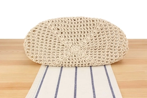 Close-up of the hand-woven circular base on a beige crochet seaside vacation bag