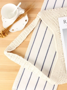 Chic beige cotton crochet tote bag with woven hollow pattern on a rustic wooden table