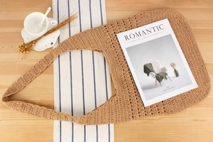 Détail d'un sac cabas en maille ajourée tissé main sur une table en bois romantique