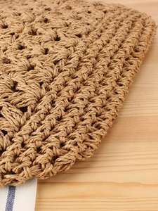 Handwoven straw bag for summer beach vacation displayed on a rustic wooden table background