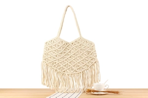 Close-up of bohemian cotton rope tote bag showing hollow weave and long fringe details