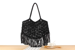 Detail of black macramé woven bag featuring intricate diamond patterns and long tassels