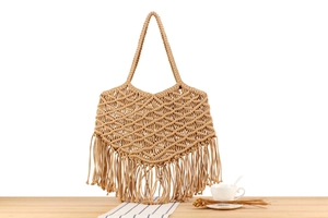 Close-up of handmade bohemian cotton rope woven tote bag with long tassel details