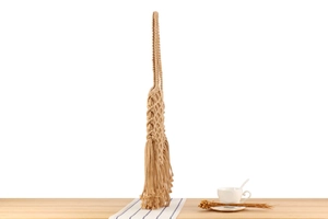 Close-up detail of bohemian woven cotton bag with long tassel fringe and soft texture