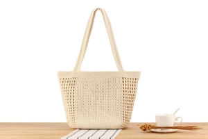 Macro detail of creamy white crochet knit tote bag with intricate hollow mesh texture