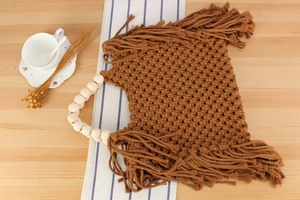 Detail of handmade cotton rope woven bag with wooden beads and fringe tassels