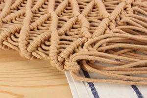 Macro shot of cotton rope weaving and tassel detail on a bohemian style tote bag