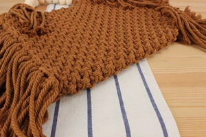 Close-up of hand-woven cotton rope handbag featuring detailed mesh texture and long fringes