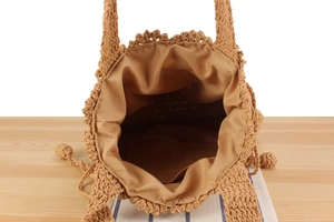 Detail of hand-woven crochet bag with spacious interior and tassel drawstring
