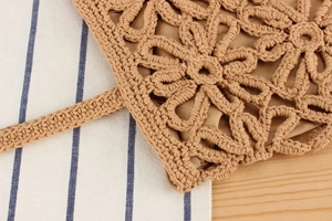 Détail d'un motif floral au crochet fait main sur un sac bohème en coton avec doublure
