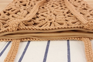 Gros plan d'un sac en coton tissé kaki avec texture florale et détail de la fermeture éclair