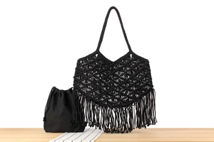Detail of black macrame tote bag with long tassels and a matching canvas inner pouch
