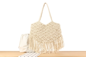 Detail of macrame woven bag with long tassels and a natural cotton drawstring inner pouch