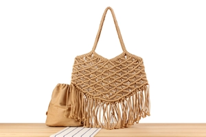 Close-up of bohemian macrame woven cotton tote bag with long tassels and beige inner pouch