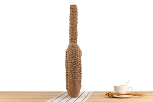 Detailed view of handmade woven shoulder bag with natural paper straw texture and braided strap
