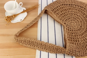 Detail of hand-woven hollow shoulder bag with soft inner lining on a wooden table