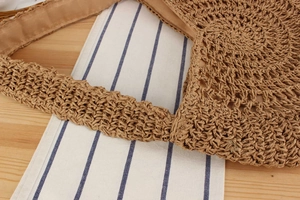 Detailed macro view of handcrafted straw weave pattern and fabric lining on shoulder bag