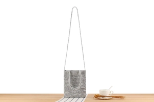 Detail of silver crochet texture and metallic chain strap on handwoven handbag