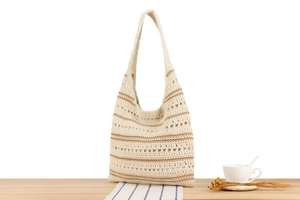 Détail d'un sac tissé à la main crème à rayures marron sur une table en bois chic