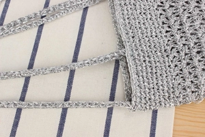Macro detail of the shiny silver crochet weave and sturdy handcrafted knot texture