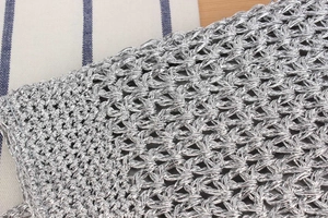 Detailed close-up of metallic silver crochet weave pattern and texture on handmade bag