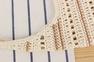 Gros plan sur le tissage au crochet fait main beige et marron d'un sac de plage d'été