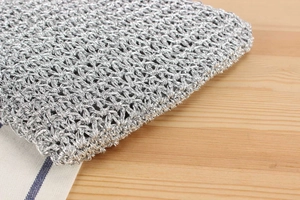 Detailed close-up of handmade silver crochet texture with fine metallic weaving craftsmanship