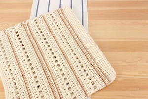 Gros plan sur la texture crochetée à la main du sac bohème à rayures crème et beige