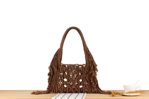 Detail view of brown handcrafted macramé tote bag with geometric knots and long fringes