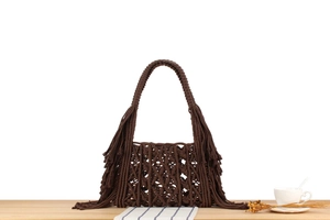 Detail shot of a dark brown macrame bag featuring intricate woven patterns and boho tassels