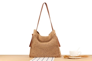 Detailed close-up of handmade woven hollow cotton rope tote bag with brown leather strap