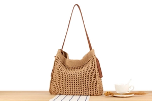 Detail of hollow woven cotton rope bag featuring a brown leather strap and mesh pattern
