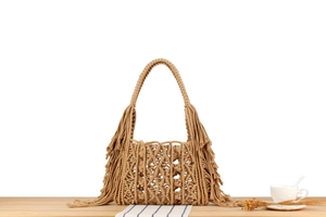 Detail of handmade khaki woven tote bag featuring long fringes and bohemian texture